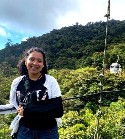 Student posing in front of rainforest 